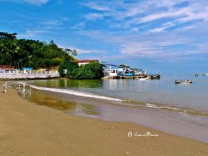 a beach with a body of water with houses and boats at Studio 187 in Rio das Ostras
