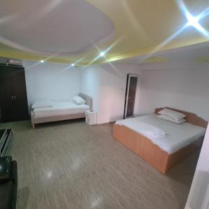 a bedroom with two beds and lights on the ceiling at CASA Ysy SUD in Eforie Sud