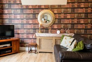 a living room with a couch and a mirror at Vintage 2-bed flat with free parking in Measham in Measham