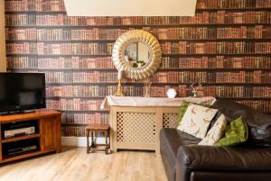 a living room with a couch and a mirror at Vintage 2-bed flat with free parking in Measham in Measham