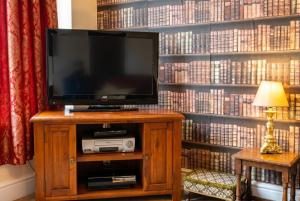 a television on a stand in front of a wall of books at Vintage 2-bed flat with free parking in Measham in Measham +27 photos