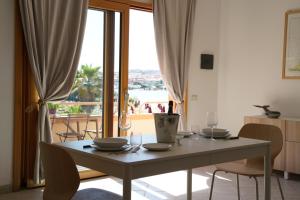 a dining room with a table with chairs and a window at Case sul mare in Palau