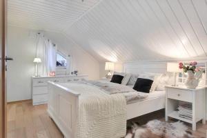 a white bedroom with a white bed and a window at RIBO Apartment Katterjåkk in Riksgränsen