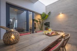 a wooden table with a plate of food on it at Entre Patios 1BR Costa Nova Beach in Gafanha da Encarnação +8 photos