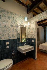 a bathroom with a sink and a toilet and a bed at Maison Ventiquattro in Talamello +102 photos