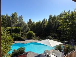 a swimming pool with an umbrella and two chairs at Lbkn in Toulouse