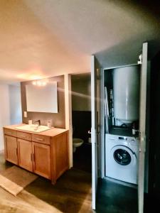 a kitchen with a sink and a washing machine at Le refuge médiéval - Appartement climatisé perché sous les toits de Billom in Billom