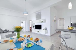 a white living room with a table with food on it at Amore Rentals - Villa Anna in Positano