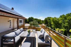a patio with couches and a table on a balcony at My Dalmatia - Villa Manda Adriatic with Private Heated Pool in Skradin