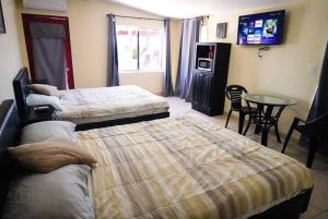 a hotel room with two beds and a table at Rancho Percebu Beach Studio 5 in San Felipe