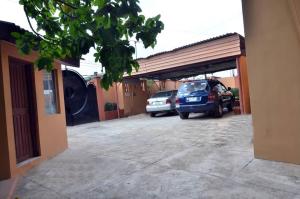 two cars parked in a parking lot next to a building at Peace Vil in Kuto