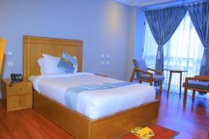 a bedroom with a bed and a table and chairs at Burqito International Hotel in Āwasa +1 photo
