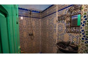 a bathroom with a sink and a tiled wall at Maison Zouala in Zouala +31 photos