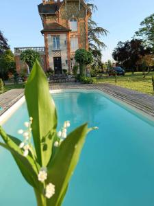 a swimming pool in front of a house with a building at Villa du Sauzin in Cronat