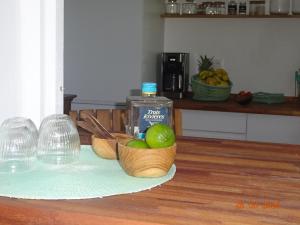a counter with two bowls of fruit and a bottle of alcohol at Le Jardin Secret in Le Vauclin +1 photo