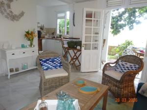 a living room with a table and chairs and a kitchen at Le Jardin Secret in Le Vauclin