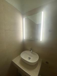 a bathroom with a white sink and a mirror at Paparizou Apartments in Kokkino Nero