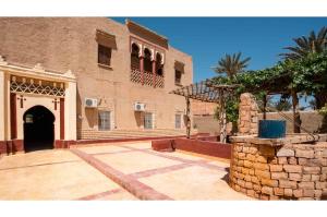 a large brick building with a door and a courtyard at Maison Zouala in Zouala