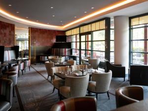 a restaurant with tables and chairs and windows at Parc Beaumont Hôtel & Spa Pau - MGallery Collection in Pau