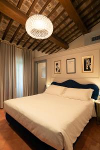 a bedroom with a large bed and a chandelier at Maison Ventiquattro in Talamello