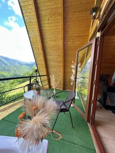 a table and chairs on a porch with a view at cottage sunrise house merisi in Merisi