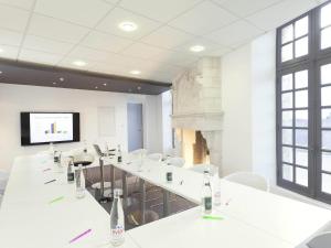 a conference room with white tables and chairs and a screen at ibis Styles Vannes Gare Centre in Vannes
