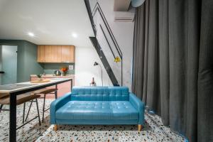 a living room with a blue couch and a kitchen at Spa & Pool - Studio Apartments 365 in Tirana