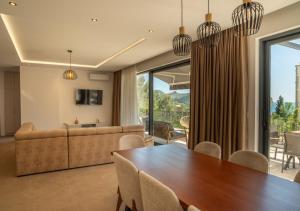 a dining room with a table and a couch at Elysium Villa in Kaluđerac