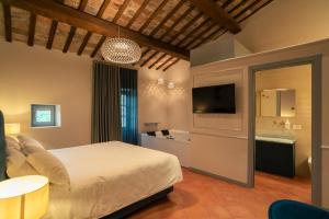 a bedroom with a bed and a tv and a table at Maison Ventiquattro in Talamello