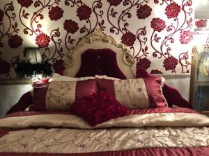 a bedroom with a bed with red pillows at Bonnye's guest house in Ramsgate