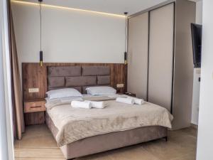 a bedroom with a large bed with two towels on it at Elysium Villa in Kaluđerac +36 photos