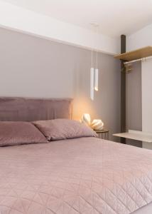 a bedroom with a large bed with a pink comforter at Diamond Gold Suite in Iraklitsa +44 photos