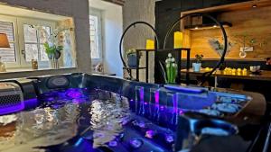 a bath tub with purple lighting in a room at Ecrin d'exception avec jacuzzi et salon cinéma in Penne-dʼAgenais +23 photos