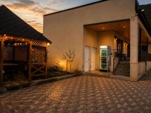 a house with a brick driveway in front of a building at Bibo's Kokhi Guesthouse in Kazbegi