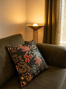 a pillow sitting on a couch with a lamp at Superbe Appartement - Centre Calvi - Parking privé in Calvi