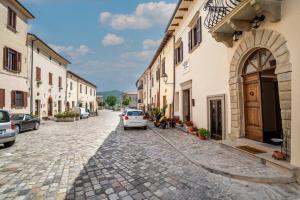 a cobblestone street with a white car parked next to buildings at Maison Ventiquattro in Talamello