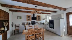a kitchen with a table and a kitchen with white cabinets at Maison de Pierre in Septfonds