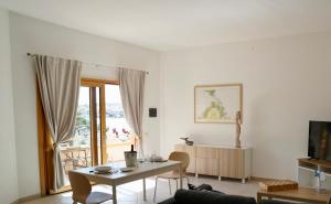a living room with a table and a television at Case sul mare in Palau