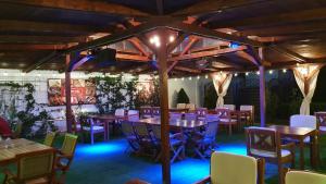 a restaurant with wooden tables and chairs and lights at GARDEN Club - Hotel & Restaurant - FREE Outdoor Pool & Parking in Braşov