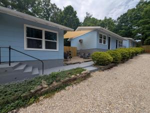 a blue house with a porch and a patio at Lazy Bull Cottages in Bull Shoals