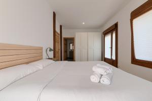 a bedroom with a white bed with towels on it at Casa Eleizpe by Next Stop Bilbao in Ergoyen +34 photos