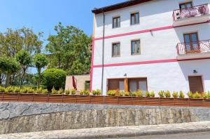 a house with a retaining wall and a stone wall at Casa Eleizpe by Next Stop Bilbao in Ergoyen