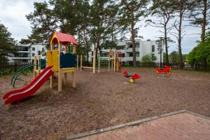 a playground with a slide and toys in a park at Apartament u Jadwigi in Jantar