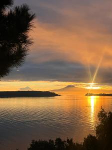 a sunset over a body of water at Cabaña con jacuzzi exterior y vista al mar - Huellas de Pato, Puerto Montt in Puerto Montt