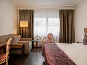 a hotel room with a bed and a couch and a window at IMLAUER HOTEL PITTER Salzburg in Salzburg +61 photos