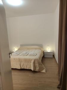 a bedroom with a bed and a white wall at Casa Aurora & Santiago in Trapani