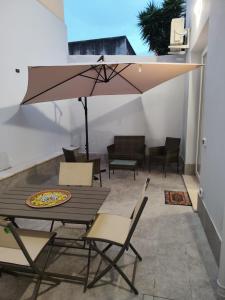a patio with a table and chairs and an umbrella at Casa Aurora & Santiago in Trapani +14 photos