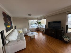 a living room with a white couch and a tv at Spacious Cottage Style Home in Toronto