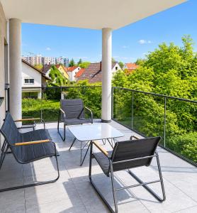 a patio with four chairs and a table on a balcony at ILA vacation home Memmingen in Memmingen