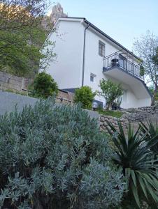 a white house with a balcony on the side of it at Mostar kuca pored jezera in Mostar